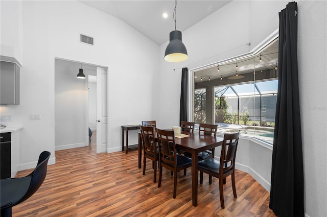 dining area featuring hardwood / wood-style floors and lofted ceiling