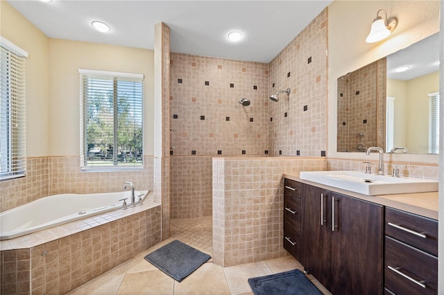 bathroom featuring shower with separate bathtub, tile patterned flooring, tile walls, and vanity