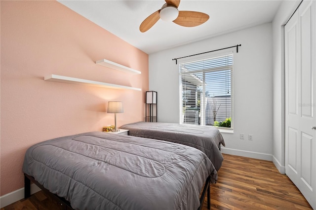 bedroom featuring dark wood-type flooring, ceiling fan, and a closet