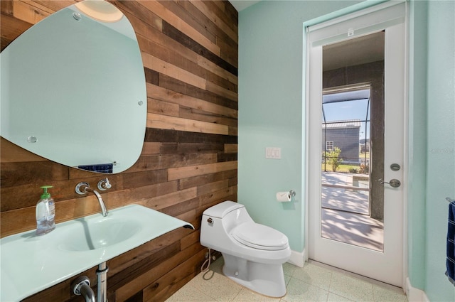 bathroom with toilet and wood walls