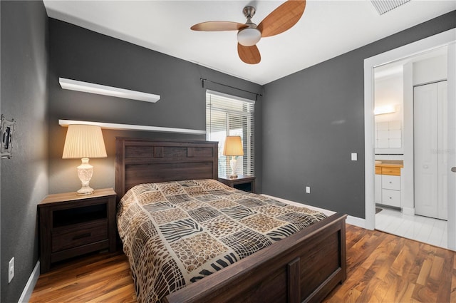 bedroom featuring ensuite bath, ceiling fan, and hardwood / wood-style floors