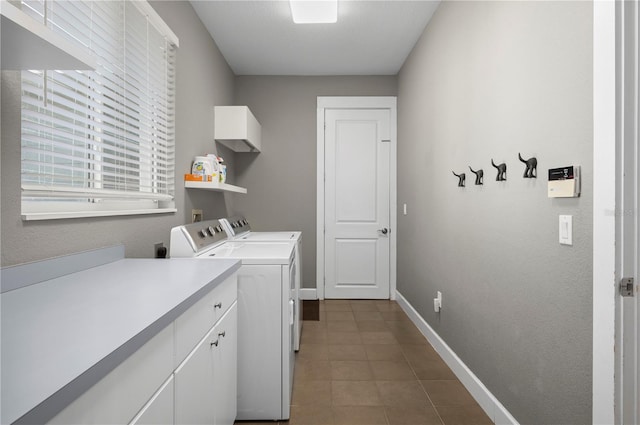 clothes washing area with washer and dryer and cabinets