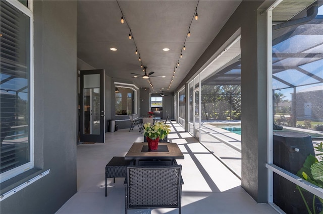 sunroom / solarium with ceiling fan and a pool