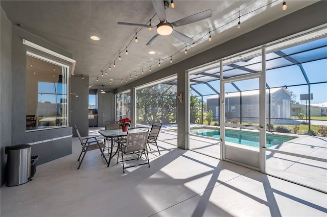 sunroom / solarium with ceiling fan and a swimming pool