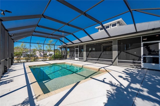 view of swimming pool featuring a lanai and a patio