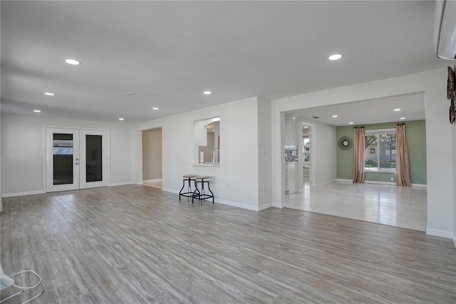 unfurnished living room featuring light hardwood / wood-style flooring and french doors