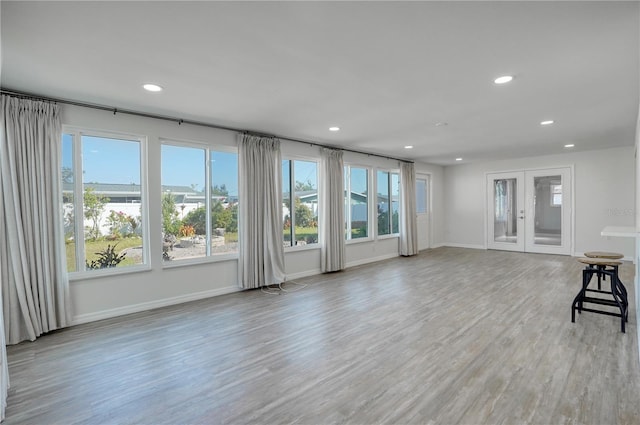 unfurnished living room featuring french doors and light hardwood / wood-style floors