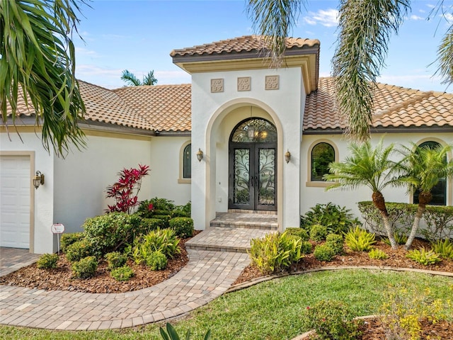 property entrance with a garage and french doors