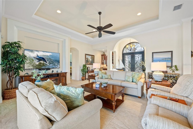 living room featuring a raised ceiling, ornamental molding, and ceiling fan