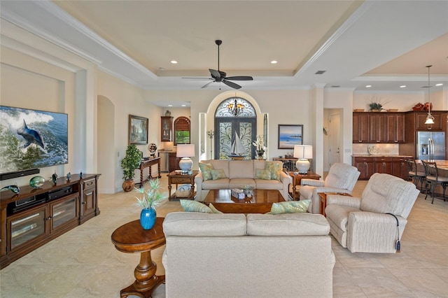 living room featuring ceiling fan, crown molding, and a raised ceiling