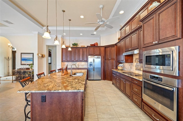 kitchen with stainless steel appliances, crown molding, a breakfast bar, and a spacious island