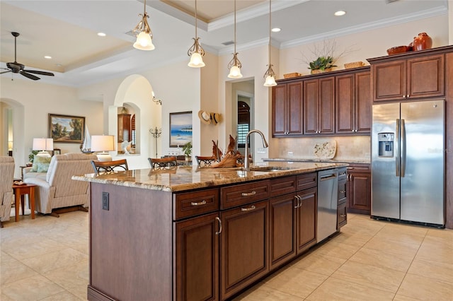 kitchen with a kitchen island with sink, sink, stainless steel appliances, and a raised ceiling