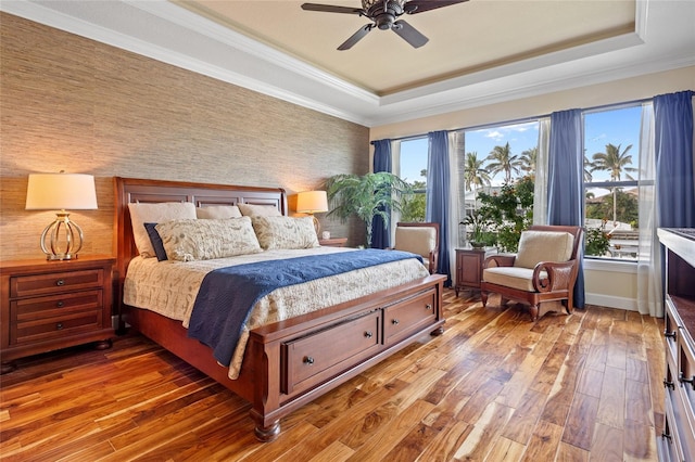 bedroom with ceiling fan, crown molding, and a tray ceiling