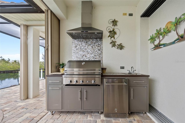 kitchen featuring wall chimney range hood, decorative backsplash, a wealth of natural light, and gray cabinets