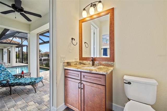 bathroom featuring toilet, ceiling fan, and vanity