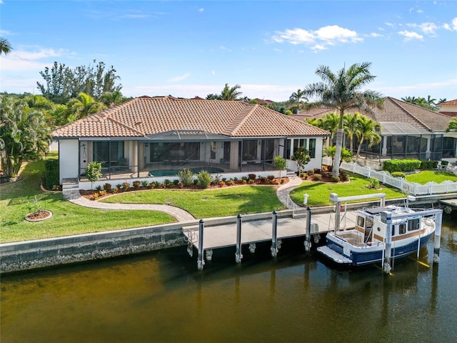 rear view of house with a water view, glass enclosure, and a lawn