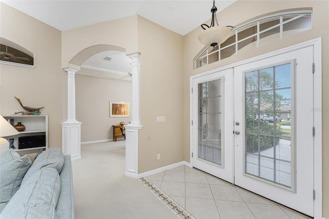 entrance foyer featuring decorative columns, light tile patterned floors, and french doors