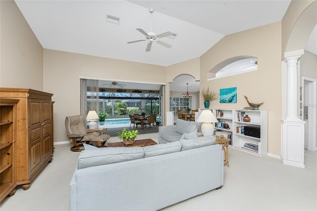 living room featuring ceiling fan, ornate columns, light carpet, and lofted ceiling