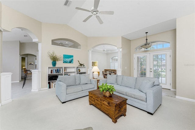 carpeted living room featuring french doors, vaulted ceiling, ceiling fan, and ornate columns