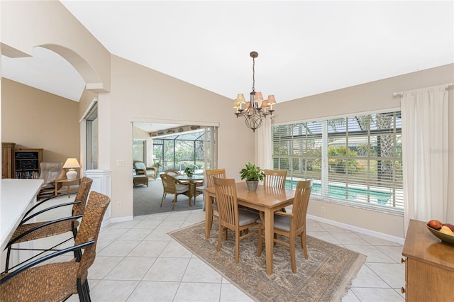 tiled dining room featuring vaulted ceiling and a chandelier