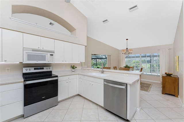 kitchen with decorative light fixtures, white cabinetry, kitchen peninsula, and appliances with stainless steel finishes