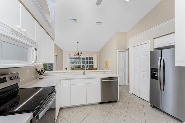 kitchen featuring pendant lighting, appliances with stainless steel finishes, sink, white cabinets, and lofted ceiling