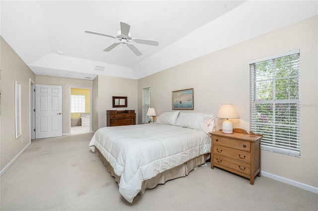 bedroom with light carpet, multiple windows, vaulted ceiling, and ceiling fan