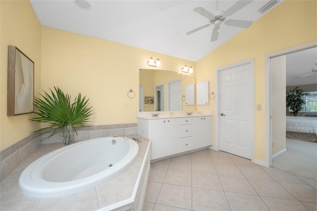 bathroom featuring vaulted ceiling, ceiling fan, tile patterned floors, a relaxing tiled tub, and vanity