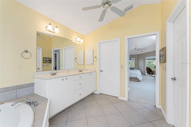 bathroom featuring ceiling fan, tiled bath, tile patterned floors, vanity, and vaulted ceiling