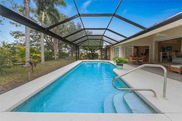 view of swimming pool featuring ceiling fan, a lanai, and a patio area