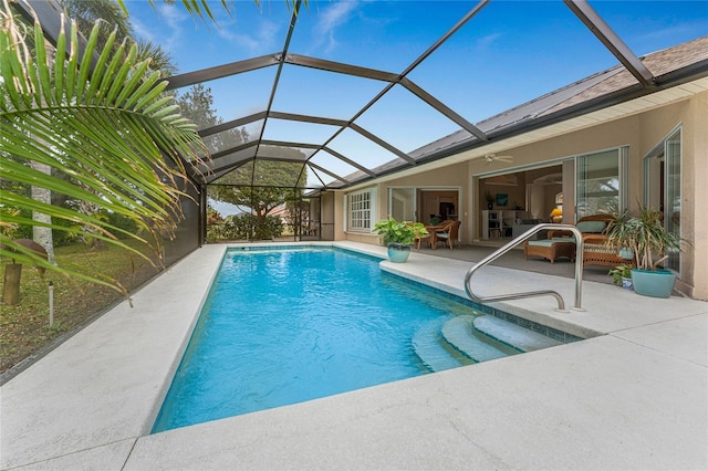 view of swimming pool featuring a patio area, a lanai, outdoor lounge area, and ceiling fan