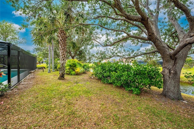 view of yard featuring a lanai and a water view