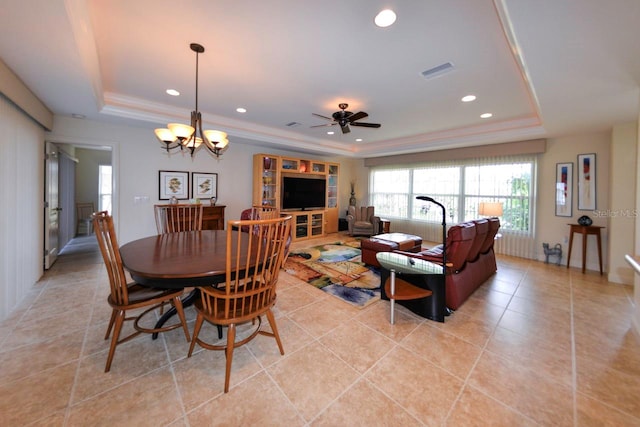 dining space featuring light tile patterned floors, a tray ceiling, and ceiling fan with notable chandelier