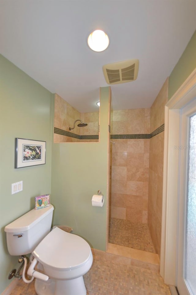 bathroom with tiled shower and toilet