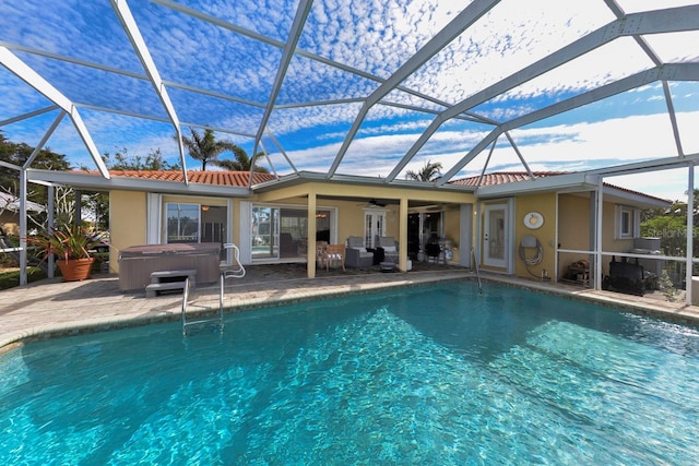 view of pool with a hot tub, a patio, ceiling fan, and glass enclosure