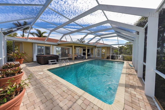 view of swimming pool with a hot tub, a patio, and a lanai