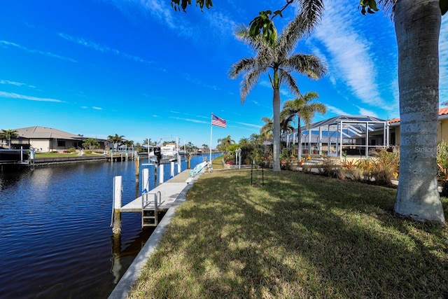 dock area featuring a water view, glass enclosure, and a lawn