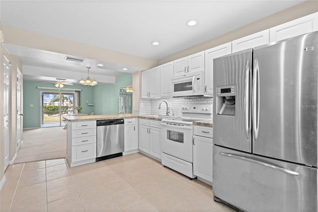 kitchen featuring kitchen peninsula, appliances with stainless steel finishes, sink, white cabinetry, and light tile patterned floors