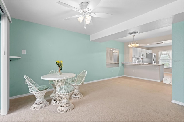 unfurnished dining area with ceiling fan with notable chandelier and light carpet