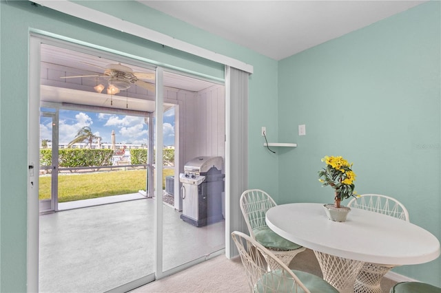 carpeted dining space with a healthy amount of sunlight and ceiling fan