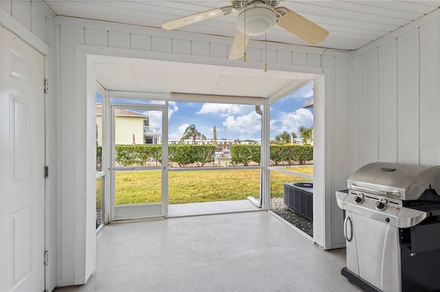 unfurnished sunroom featuring ceiling fan