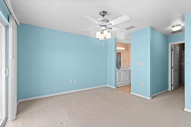 unfurnished bedroom featuring light carpet, connected bathroom, and ceiling fan