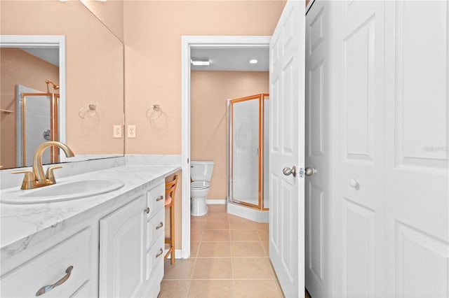 bathroom with vanity, toilet, walk in shower, and tile patterned flooring