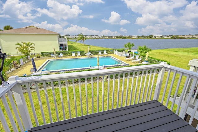 view of pool with a water view and a lawn