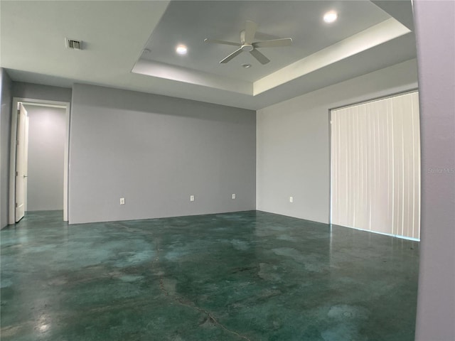 spare room featuring a raised ceiling and ceiling fan