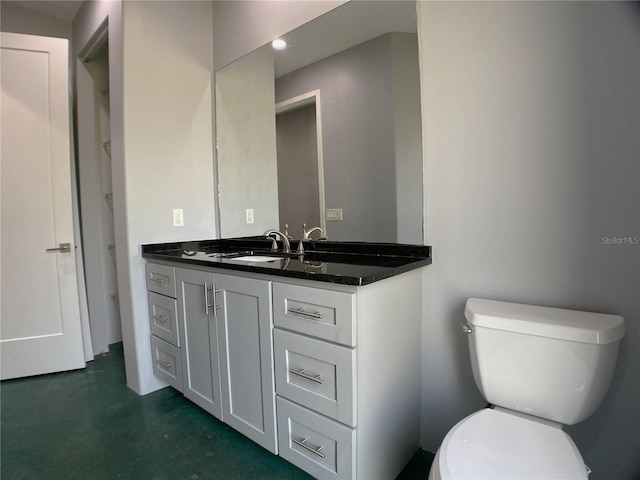 bathroom with toilet, vanity, and concrete flooring