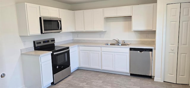 kitchen featuring sink, white cabinets, appliances with stainless steel finishes, and light wood-type flooring