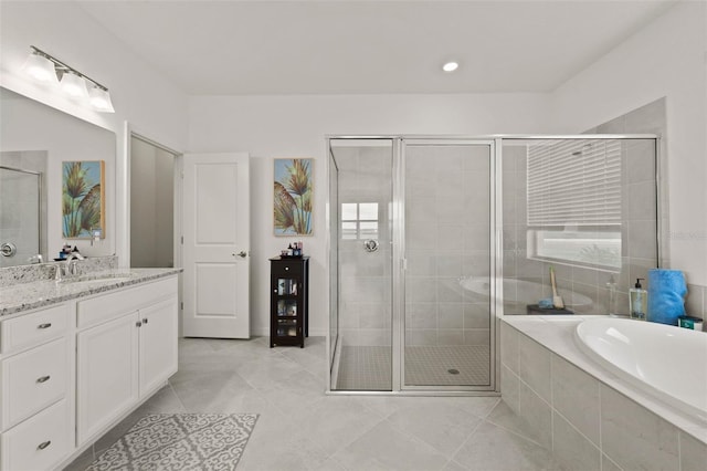 bathroom featuring vanity, independent shower and bath, and tile patterned floors