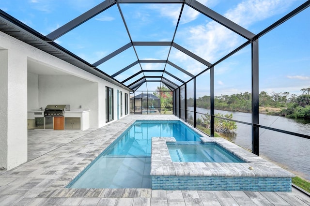 view of pool with glass enclosure, exterior kitchen, a water view, an in ground hot tub, and a patio