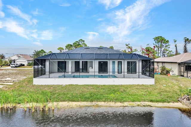 rear view of property featuring glass enclosure, a water view, a yard, and a patio